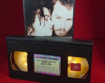 VHS nightlight of till Human Voices wake us in warm yellow.