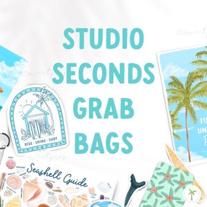 May include: A collection of colorful beach-themed items, including a seashell guide, a sticker with a beach house and the text "Rise Shine Surf", and a tote bag with a palm tree design. The text "Studio Seconds Grab Bags" is written in large, blue letters across the top of the image.