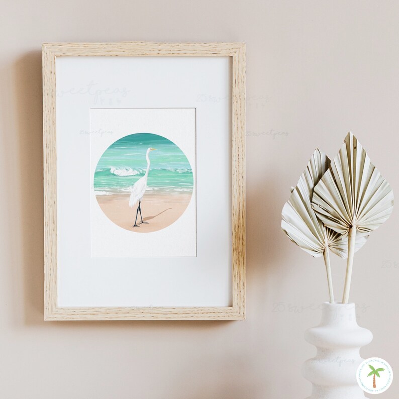 An Art Print of a gouache painting of a Great Egret on the beach right near the shoreline