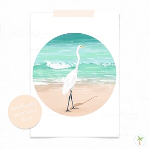 An Art Print of a gouache painting of a Great Egret on the beach right near the shoreline