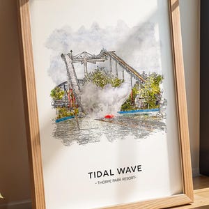 May include: A framed print of the Tidal Wave ride at Thorpe Park Resort. The artwork is a watercolour-style illustration of the ride, with the text "TIDAL WAVE" and the resort name. The frame is made of light-coloured wood.