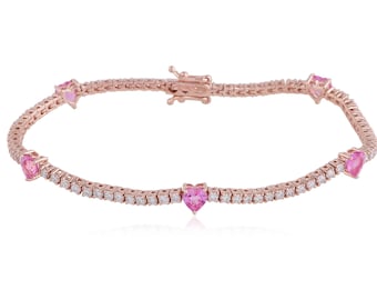 May include: Rose gold bracelet featuring a delicate chain design. The bracelet is adorned with small, sparkling white stones and heart-shaped pink gemstones. The clasp is also rose gold.