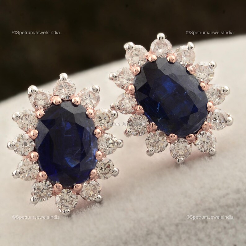 Puede incluir: Un par de pendientes con una gran piedra de zafiro azul ovalada rodeada por un halo de diamantes blancos m&aacute;s peque&ntilde;os. Los pendientes tienen un engaste de oro rosa.