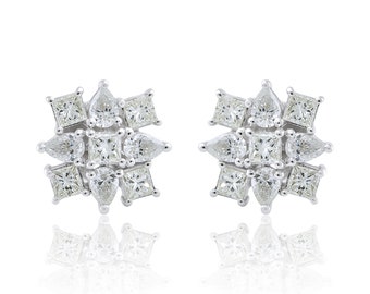 Op de afbeelding: Een paar diamanten oorstekers. Elke oorbel heeft een bloemmotief met vierkante en peervormige diamanten. De oorbellen zijn gezet in een zilverkleurig metaal. De diamanten zijn helder en sprankelend.