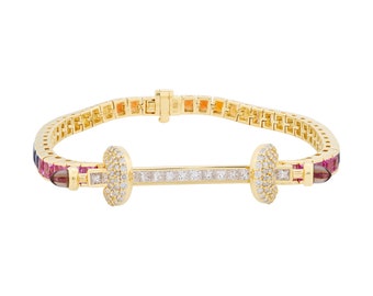 Puede incluir: Pulsera dorada con un diseño de barra central, adornada con piedras preciosas blancas y transparentes. La pulsera presenta una serie de piedras preciosas de colores en tonos rosa, naranja y azul. El cierre es visible, sobre fondo blanco.
