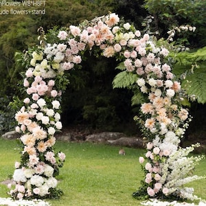 K&ouml;nnte beinhalten: Ein dekorativer Blumenbogen, ca. 244 cm breit und 244 cm hoch, mit wei&szlig;en, pfirsichfarbenen und rosa Bl&uuml;ten. Der Bogen steht auf einer gr&uuml;nen Wiese, mit dem Text "ArchFlowers W8*H8FT include flowers + stand".