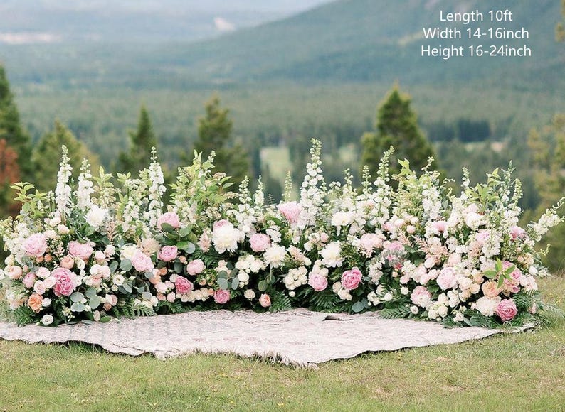 Op de afbeelding: Een bloemenboog gemaakt van witte en roze bloemen, groen en varens. De boog is 3 meter lang, 35-40 cm breed en 40-60 cm hoog.