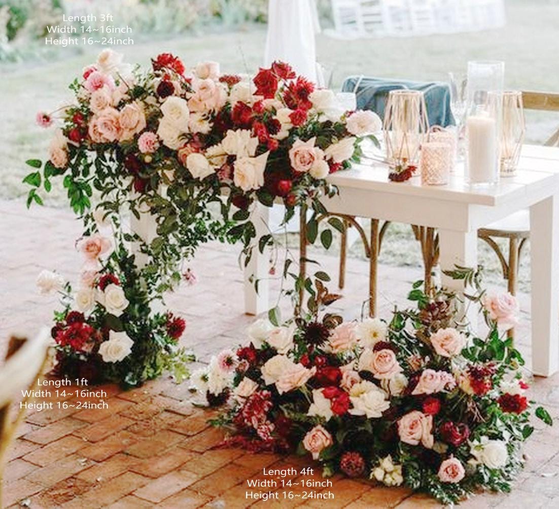High-impact luxury wedding flowers with roses and greenery placed strategically at main table