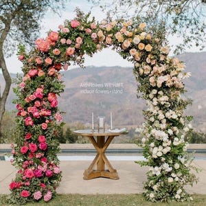 K&ouml;nnte beinhalten: Ein dekorativer Blumenbogen, geschm&uuml;ckt mit rosa, pfirsichfarbenen und wei&szlig;en Rosen und Gr&uuml;n. Der Bogen ist etwa 244 cm breit und 244 cm hoch. Vorne steht ein Holztisch mit Kerzen. Der Text auf dem Bild lautet "ArchFlowers W8*H8FT include flowers + stand."