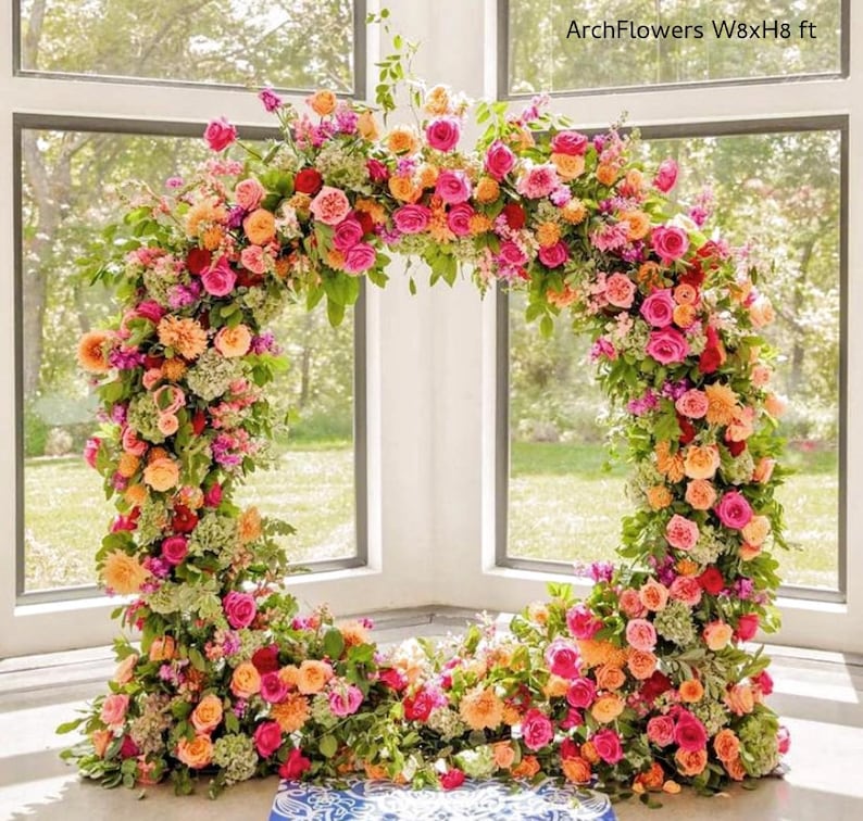 May include: A floral archway, approximately 8 feet wide and 8 feet high, composed of vibrant pink, orange, and red roses, with green foliage. The text "ArchFlowers W8xH8 ft" is visible.