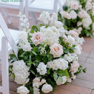 Puede incluir: Un pasillo de ceremonia de boda decorado con un gran arreglo de flores blancas y rosa p&aacute;lido. Las flores incluyen rosas, hortensias y otras flores. El arreglo mide aproximadamente 60 cm de largo, 35-40 cm de ancho y 35-50 cm de alto.