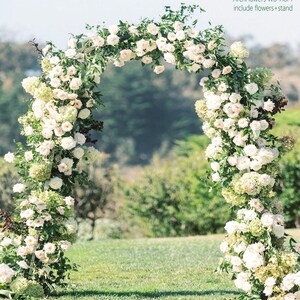 K&ouml;nnte beinhalten: Ein wei&szlig;er Blumenbogen, perfekt f&uuml;r Hochzeiten oder besondere Anl&auml;sse. Der Bogen ist mit &uuml;ppigen wei&szlig;en Rosen und Gr&uuml;n geschm&uuml;ckt und schafft eine romantische und elegante Pr&auml;sentation. Der Text "ArchFlowers W8*H8FT include flowers+stand" ist sichtbar.
