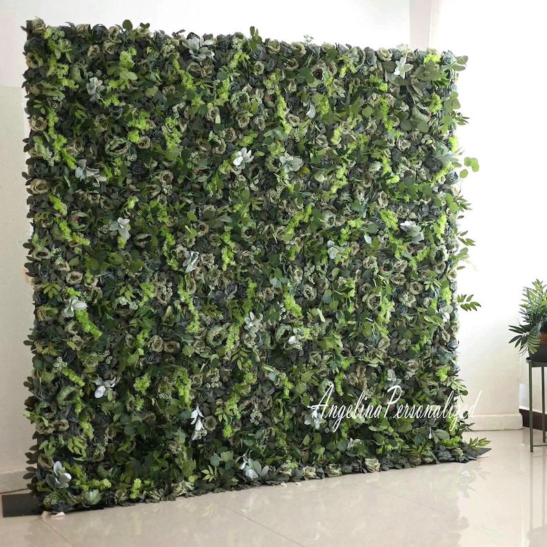 May include: A green artificial flower wall backdrop with a variety of green leaves and flowers. The wall is made of individual pieces that can be arranged to create a custom design. The wall is perfect for weddings, parties, and other events.