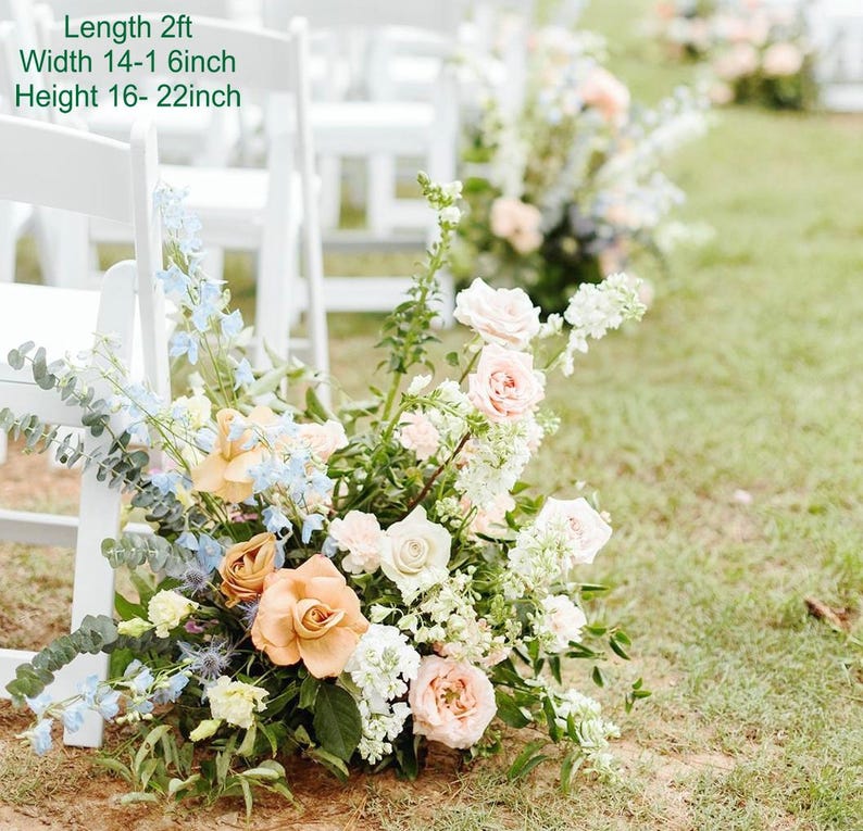 Puede incluir: Un pasillo de boda decorado con sillas blancas y arreglos florales. Los arreglos est&aacute;n hechos con flores blancas, melocot&oacute;n y azules. Las flores est&aacute;n dispuestas en cascada y tienen aproximadamente 60 cm de largo, 35-40 cm de ancho y 40-55 cm de alto.