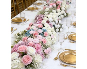 Puede incluir: Una mesa bellamente decorada con un centro de mesa floral. El arreglo presenta rosas rosas, blancas y azules, hortensias y paniculata. Platos, cubiertos y sillas doradas complementan el mantel blanco. El texto "AngelinaPersonalized" es visible.