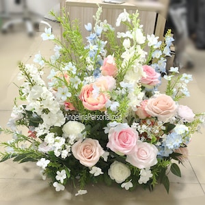 May include: A floral display with pink, white, and blue flowers, including roses and peonies, and green foliage. The arrangement is a mix of different blooms. The text "AngelinaPersonalized" is visible.