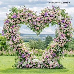 May include: A heart-shaped floral arch, approximately 8 feet wide and 8 feet high, composed of pink, purple, and white flowers. The arch is set on a green lawn with a scenic background of trees and a cloudy sky. Text on the image reads "ArchFlowers W8xH8 ft."