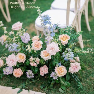 May include: A floral arrangement featuring light pink and peach roses, light blue delphiniums, and small white flowers with green foliage. Text on the image indicates a length of 3ft, a width of 14-16 inches, and a height of 16-22 inches.