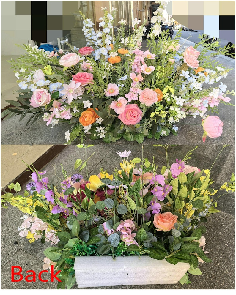 May include: A floral arrangement in a rectangular white planter featuring a mix of pink, orange, and white artificial flowers with green foliage. The top section displays roses and small blossoms, while the bottom section shows the planter with the text Back.