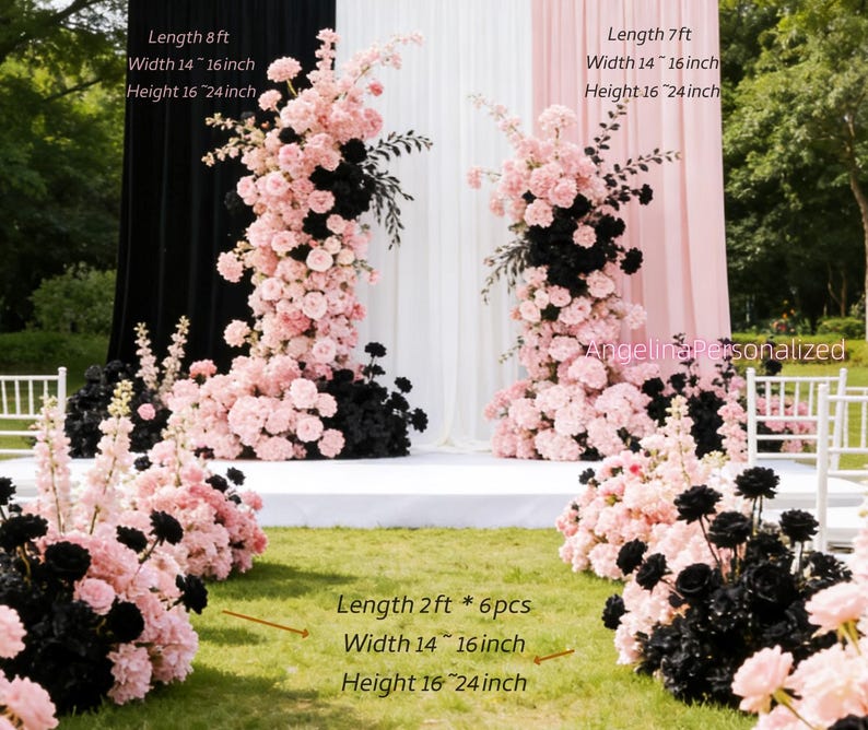 May include: Floral arrangement with pink and black flowers, used for wedding decor. The arrangement is set against a backdrop of black, white, and pink fabric. The height is 16-24 inches, and the width is 14-16 inches.