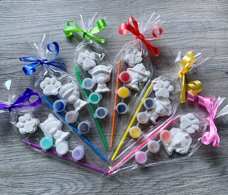 Pu&ograve; includere: Un set di sei figurine in ceramica da dipingere, confezionate in sacchetti di plastica trasparenti con nastri colorati. Ogni figurina rappresenta un animale diverso, tra cui un cane, un gatto e un uccello. I sacchetti includono anche barattoli di vernice e pennelli.