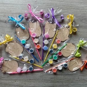 May include: A set of ten paint-your-own wooden animal figures with paint pots and brushes. The figures are packaged in clear plastic bags with colourful ribbons.