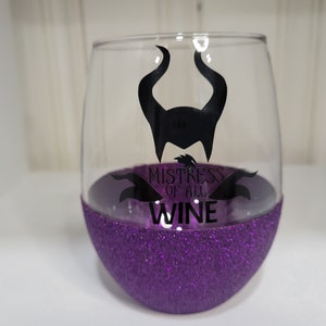 May include: Purple glitter wine glass with a black silhouette of Maleficent's horns and the text "Mistress of all Wine".