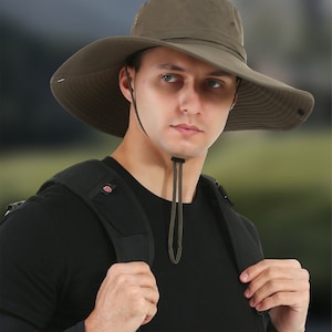 May include: An olive green wide-brimmed sun hat featuring a chin strap with an adjustable toggle. The hat includes text stating "Multi-function sunbonnet" and "Cycling/fishing/mountaineering" with a 12-inch brim measurement graphic.