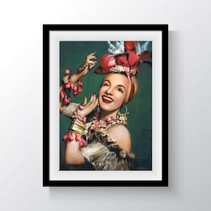 May include: A woman with dark hair and red lipstick wears a large, red, flower-shaped headdress with a white feather. She is wearing a white and gold dress and a lot of pink jewelry. The background is a dark green.