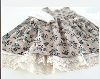 2-piece cotton dress with a summery floral pattern and lace on the hem and lace on the pockets
