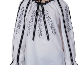May include: White embroidered blouse with black lace trim and a tie at the neck.