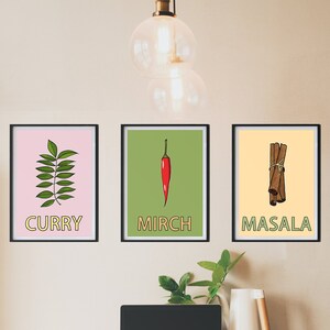 May include: Three framed prints with illustrations of spices and their names in English and Hindi. The prints are hung on a light beige wall. The prints are labeled "Curry", "Mirch", and "Masala".