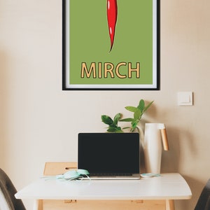 May include: A framed print with a green background and a red chili pepper illustration. The word "MIRCH" is written in orange below the pepper.
