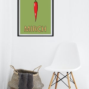 May include: A framed print with a green background and a red chili pepper illustration. The word "MIRCH" is written in orange below the pepper.