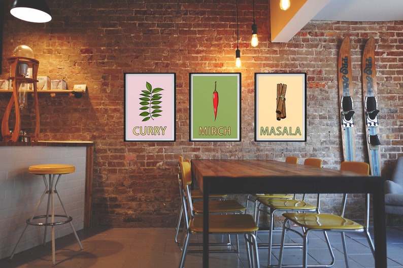 May include: Three framed prints with illustrations of Indian spices. The prints are hung on a brick wall in a cafe setting. The prints are labeled "Curry", "Mirch", and "Masala".