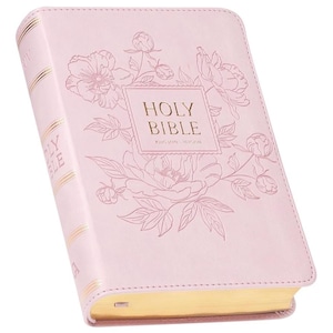 May include: A light pink Holy Bible with gold gilded edges. The cover features a floral design and the words "Holy Bible" in gold lettering. The spine has gold accents. The book is closed and angled slightly.