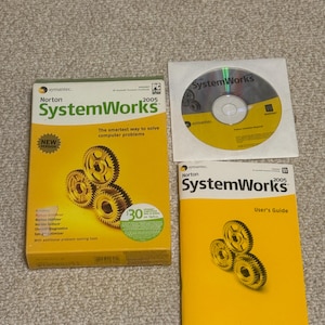 May include: A yellow box set of Norton SystemWorks 2005 software, a CD, and a user's guide. The box and guide feature the text "SystemWorks" and "2005". The CD is in a clear plastic sleeve. The box has a "New Version" sticker.
