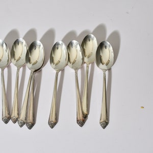 May include: Set of eight silver teaspoons with ornate handles.
