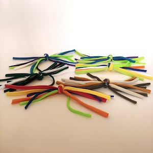 May include: Assortment of colorful fabric rope toys with knots at the ends. The toys are made of different colors, including green, blue, white, orange, red, yellow, and brown.