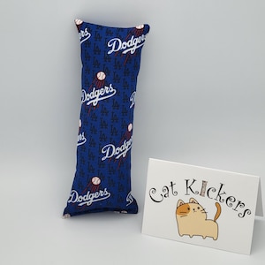 May include: Blue and white catnip toy shaped like a pillow with the Los Angeles Dodgers logo and the text "Cat Kickers".
