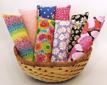 May include: A wicker basket filled with colorful fabric catnip toys. The toys are in various patterns, including floral, polka dot, and rainbow.