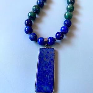 Lapislazuli-Anhänger an einer geknoteten Halskette aus Lapislazuli und Chrysokoll.