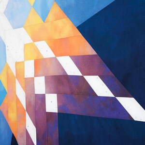 Op de afbeelding: Abstracte geometrische patroon quilt met een mix van blauwe, witte, oranje en paarse stof vierkanten.