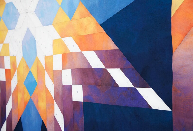 Op de afbeelding: Abstracte geometrische patroon quilt met een mix van blauwe, witte, oranje en paarse stof vierkanten.