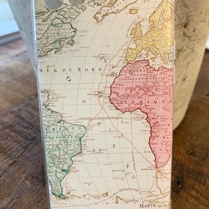 May include: A white phone case with a vintage world map design. The map is in shades of green, yellow, pink, and brown. The map includes the text "TERRES ARCTIQUES" and "MER DU NORD".