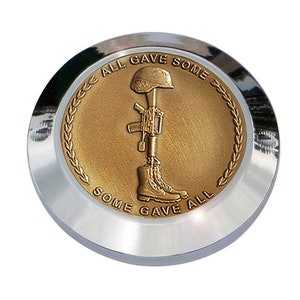 May include: A chrome motorcycle accessory with a gold-toned emblem featuring a soldier's boot, rifle, and helmet with the text "All Gave Some, Some Gave All".