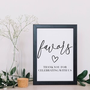Może przedstawiać: Czarny, oprawiony znak z białym tłem i tekstem "favors" napisanym kursywą, z małym sercem poniżej. Pod sercem znajduje się tekst "Thank you for celebrating with us".