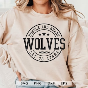 May include: Beige sweatshirt with a black circular graphic that reads "Hustle and Heart Wolves Set Us Apart." The design includes stars and a checkered pattern. The bottom of the image shows the file types: SVG, PNG, DXF, and EPS.