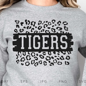 May include: A gray sweatshirt with a black leopard print design and the word "TIGERS" in black text with white outlines.