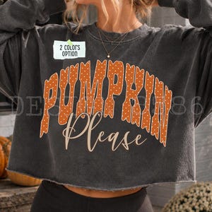 Könnte beinhalten: Ein anthrazitfarbenes bauchfreies Sweatshirt mit dem orangefarbenen Schriftzug PUMPKIN mit weißen Punkten in geschwungener Schrift, gefolgt von dem Wort Please in Schreibschrift. Ein kleines weißes Etikett zeigt 2 COLORS OPTION.
